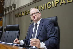 Movimentação de plenário. Ao microfone, o vereador Tiago Albrecht preside a sessão momentaneamente.