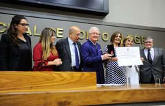 Edison Magalhães (c) recebe o diploma entregue por Mônica Leal