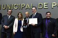 A distinção foi entregue ao homenageado pelo vereador Reginaldo Pujol (c)