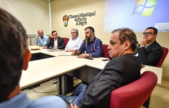 Informações sobre cumprimento da Lei dos Táxis. Representantes da EPTC e associações de taxistas na mesa e platéia.
