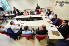 Informações sobre cumprimento da Lei dos Táxis. Representantes da EPTC e associações de taxistas na mesa e platéia.