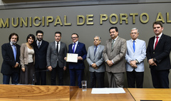 Vice-reitor segura o diploma conferido à PUCRS pela Câmara Municipal