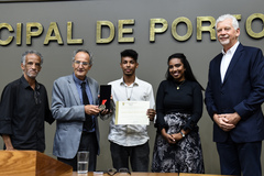 Danyel Oliveira (c) recebe a Comenda e o diploma entregues por Ferronato (e)