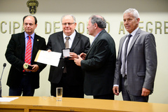 Argollo (c) recebe a comenda entregue por Dr. Goulart (d)