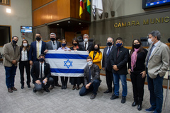 Sessão ordinária híbrida. Na foto, vereadores e a bandeira do Estado de Israel. Em ordem: Moisés Barboza, Mari Pimentel, Alexandre Bobadra, Felipe Camozzato (agachado), Ramiro Rosário, Fernanda Barth, Comandante Nádia, Mauro Pinheiro, Claudia Araújo, Jessé Sangali (agachado), Idenir Cecchim, Giovane Byl, Psicóloga Tanise Sabino e Cassiá Carpes