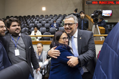 Movimentação de plenário. Secretário André Barbosa é cumprimentado por vereadora Claudia Araújo após aprovação de projeto