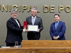 Ramiro Rosário entregando homenagem ao pastor Airton Scheunemann Schroeder, vice-presidente da IELB. Foto: OAJ