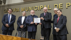 Wachholz e Albrecht exibem o diploma em homenagem à editora